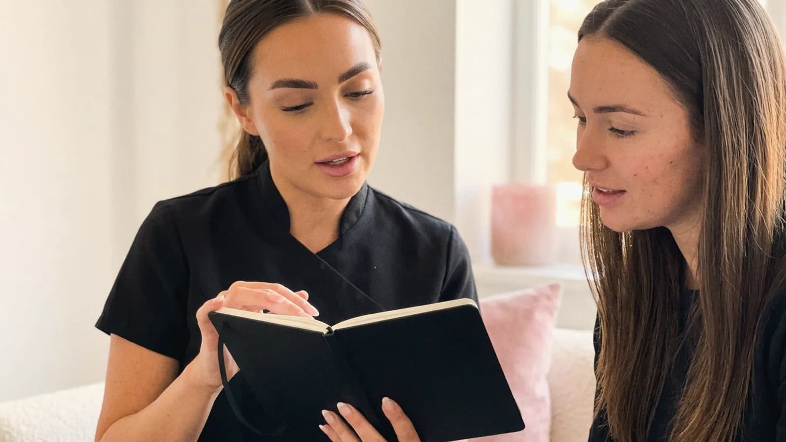 A nurse practitioner talks through her reflective notes with a colleague.
